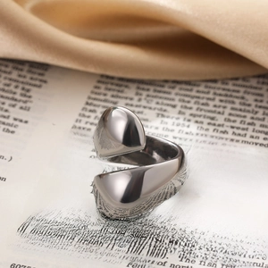 Macro shot of polished silver teardrop knot ring on vintage book with silk fabric