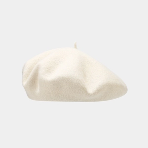 Detailed macro view of beige wool beret featuring soft fiber texture and top knot detail