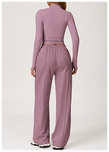 Detail of high waist pleated waistband on mauve wide leg sports trousers with seam