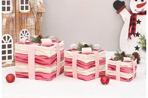 Detailed view of pink and beige Christmas gift boxes with pine cones and velvet ribbons