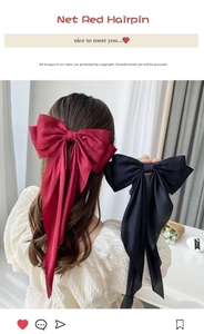 Detail of red and black satin bow hair clips with long ribbons in an elegant style