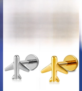 Detailed close-up of airplane shaped G23 titanium ear studs in gold and silver finishes