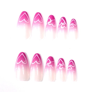 Detail of pink gradient almond press-on nails featuring white heart and star patterns