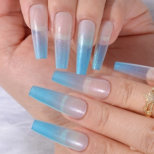 Close-up of long coffin press-on nails with nude to blue glitter gradient on fingers