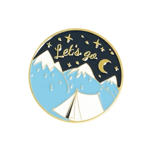 Detail of round camping enamel pin with snow mountains, tent and Let's go text