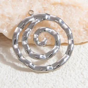 Detailed view of silver spiral stainless steel pendant on textured white stone background