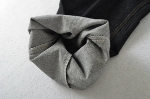 Dettaglio delle cuciture a contrasto e della trama twill su un orlo denim largo