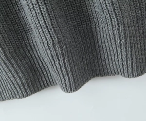 Macro view of grey ribbed knit hem showing detailed texture on long cardigan sweater