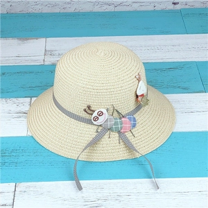 Close-up of beige straw sun hat with grey polka dot ribbon and colorful caterpillar patch