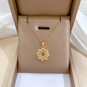 Luxury gold titanium flower necklace with clear crystals in a beige jewelry box