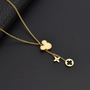Detail of gold titanium steel necklace featuring Mickey and clover charms on a dark surface
