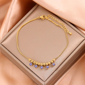 Golden titanium steel anklet with blue evil eye charms and gold beads on silk