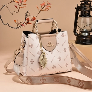 Contrast leather shoulder bag for women with gold chain and handle in warm studio setting