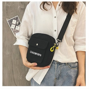 Minimalist black canvas crossbody bag with adjustable strap and decorative side buckle