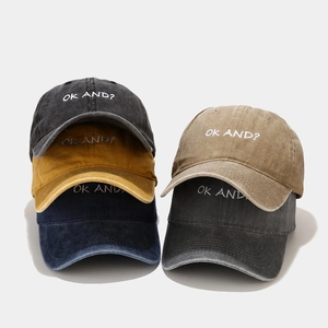 Close-up of vintage washed cotton baseball caps with OK AND embroidered text in five colors