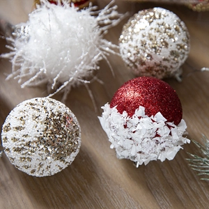 Festive Christmas ball ornaments set with glitter and velvet textures on wooden background
