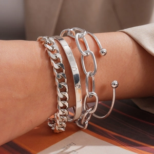 Detailopname van een 4-delige zilveren metalen armbandset met gegraveerde manchet