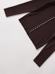 Detail of coffee brown ribbed knit sweater with button closure and lettuce trim edges