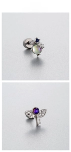Detail of titanium steel ear studs featuring a purple zircon heart and celestial planet designs
