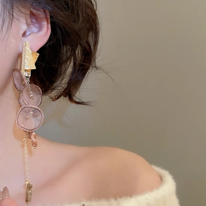 Detail view of elegant chiffon flower tassel earrings with long gold chain on model
