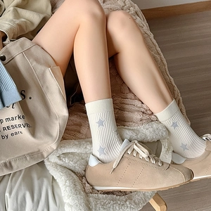 White crew socks with blue stars and ribbed cuffs shown with sneakers and tote bag