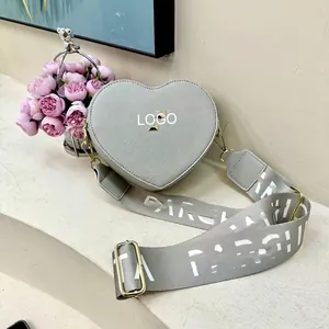 Minimalist light gray heart-shaped leather crossbody bag with patterned wide strap