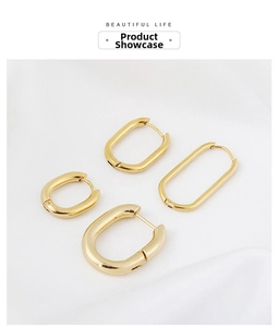 Detail showing four sizes of polished golden U-shaped oval earrings on white fabric