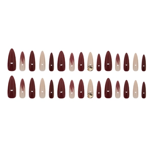 Long almond press-on nails with red marble gradient design and sparkling rhinestone accents