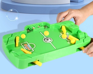 Close-up of hands operating the green tabletop football game with ejection paddles