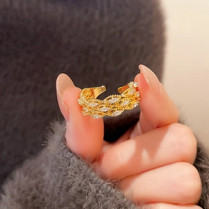 Close-up of vintage gold flower ring with cubic zirconia and woven textured band