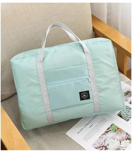 Foldable mint green travel bag placed on a modern sofa showing waterproof nylon texture