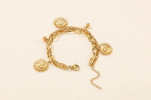 Detail of double-layer gold titanium steel bracelet with sun pendants and lobster clasp
