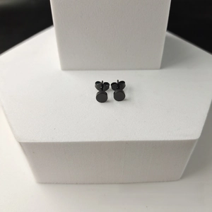 Detail view of matte black 316L stainless steel flat disc stud earrings on display