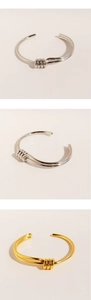 Macro detail of intertwined spiral knot design on gold and silver plated open bangles