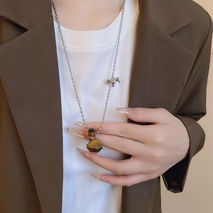 Detail of silver bead necklace with brown tiger eye Saturn pendant and small pony charm