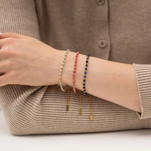 Three colorful beaded stainless steel bracelets in white, rose, and blue on a model wrist
