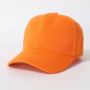 Close-up of bright orange baseball cap showing twill cotton texture and embroidery holes