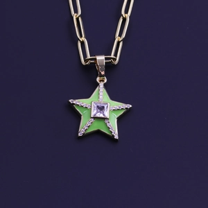 Macro detail of gold star pendant with green enamel and sparkling zircon stones