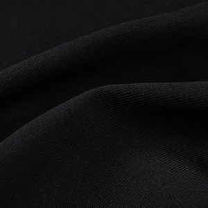 Dettaglio macro del tessuto a maglia a coste nere con pieghe morbide e trama elegante