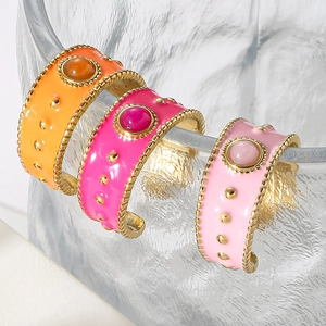 Detailed close-up of wide enamel rings with colorful finish and round center stones