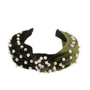Olive green velvet headband with pearls and a knotted design on a white background