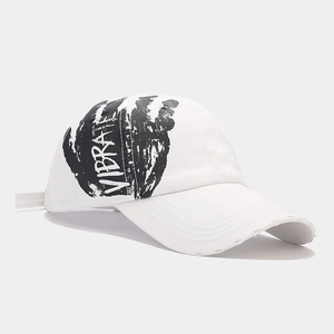 Detail of distressed brim and VIBRATE graffiti print on a white street-style baseball cap