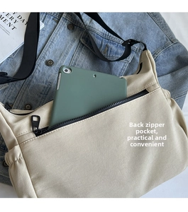 Rear zip pocket of beige crossbody bag showing space for a tablet and daily essentials