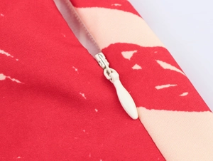 Detail of invisible zipper with teardrop puller on a red palm print vacation dress