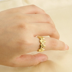 Vue détaillée d'une bague tête de mort dorée style punk en acier inoxydable sur le doigt