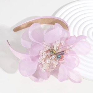 Detail of pink floral headband with sparkling crystal center and golden wire accents