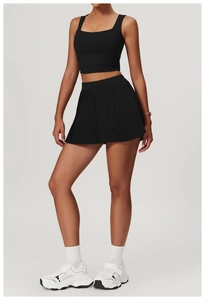 Full view of black sports set with cropped tank top and pleated tennis skirt on model