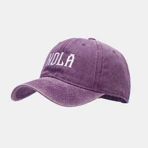 Close-up of vintage washed cotton baseball cap with white NOLA embroidery in deep purple
