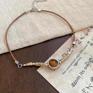 Detail view of amber resin pendant with wooden beads on ethnic geometric necklace