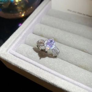 Close-up of elegant silver flower ring with purple oval gemstone and pavé diamonds